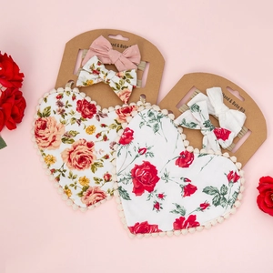 Detail of heart-shaped cotton baby bibs and elastic headbands in a gift box set