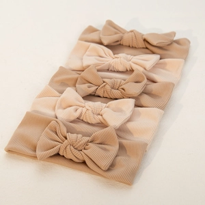 Detailed view of 5-pack ribbed fabric baby headbands with bows in earthy tones