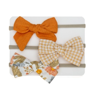 Detail view of baby bow headband set showing cotton textures and floral print patterns