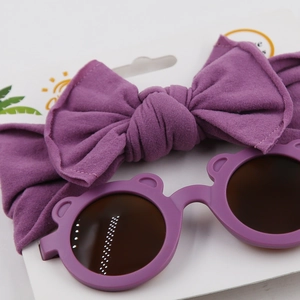 Detailed view of dark purple baby headband and cute bear-eared sunglasses set
