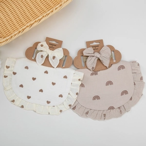 Detailed set of cotton baby bibs with ruffles and matching bows in heart and rainbow prints