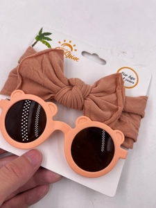 Detail of baby bear sunglasses and matching nylon bow headband set on display card
