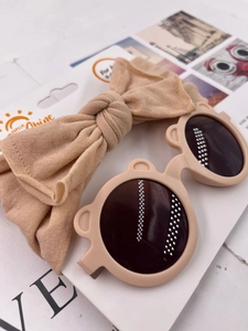 Infant beige bear ear sunglasses and matching knotted headband set on a display card