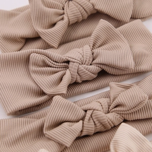 Macro detail of elastic ribbed cotton baby headbands with bow in warm mocha color