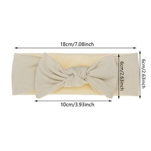 Soft beige bow headband for babies in ribbed knit fabric with size measurements