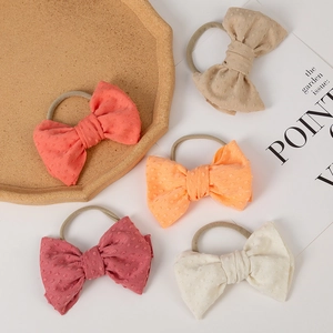 Detailed close-up of five colorful textured bow headbands for babies with jacquard dots