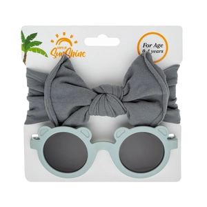 Detail of infant gift set with gray bow headband and bear-shaped sunglasses for ages 0-4