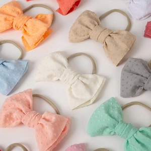 Close-up of soft nylon baby headbands featuring textured jacquard bow details in pastel colors