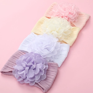 Dettaglio di quattro fasce per neonati con grandi fiori in chiffon e trama a trecce