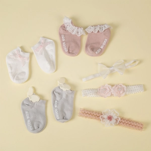 Detailed flat lay of cotton baby socks and headbands with lace and bow embellishments