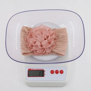 Fascia neonata in maglia rosa con grande fiore in chiffon su bilancia digitale