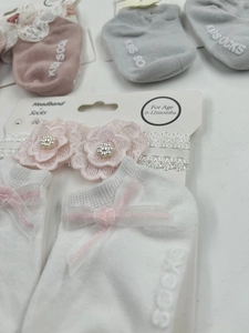 Detailed set of white baby lace headband with pink flowers and matching bow socks