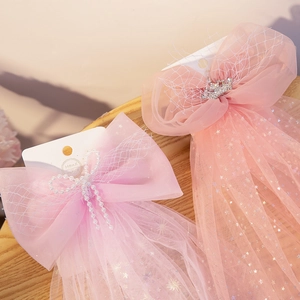 Pink tulle bow hair clips with stars and crown details on white presentation card