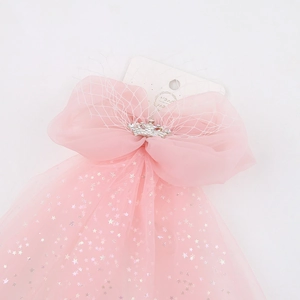 Detailed macro of pink chiffon bow hair clip with silver crown and star sequins