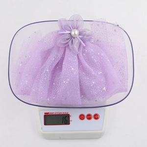 Detailed shot showing the 16g lightweight purple mesh flower hair clip on a digital scale