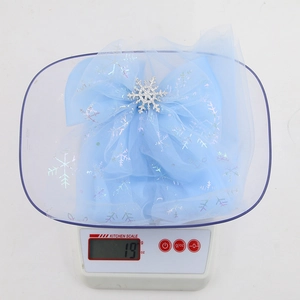 Detail of light blue mesh bow hair clip with silver snowflakes and rhinestone center