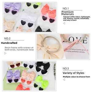 Dettaglio di occhiali da sole a cuore e fasce in chiffon in vari colori vivaci e setosi