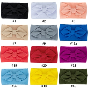 Set of 12 soft waffle knit baby headbands with large bows in various vibrant colors