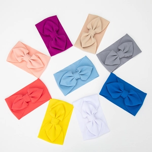 Detail view of 9 assorted colors soft waffle knit baby headbands with large bow accents
