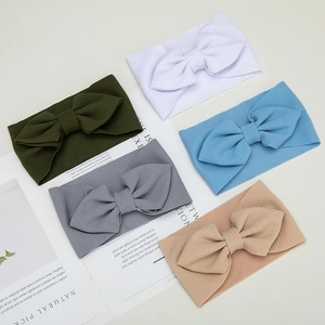 Detail showing five-piece waffle texture baby headbands with large bows in varied colors