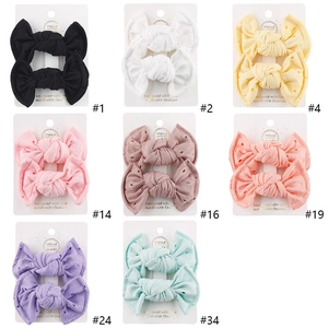Detail showing 8 pairs of lace eyelet bow hair clips in various vibrant colors on cards