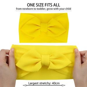 Stretch demonstration of yellow waffle knit baby headband showing its high elasticity