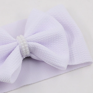 Detail of light purple baby headband with honeycomb texture and pearl bow embellishment