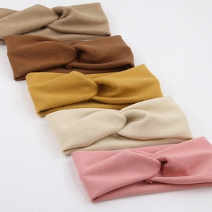 Detailed set of five soft elastic cross-knot headbands in neutral earth-tone colors