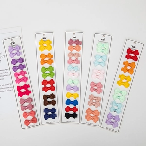 Flat lay of five sets of grosgrain ribbon bow hair clips in assorted vibrant colors