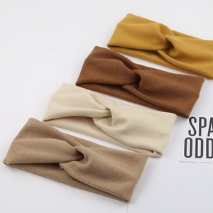 Detailed texture of four solid color twisted elastic headbands in soft earth tones