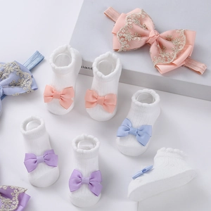 Détails du coffret chaussettes et bandeau bébé avec nœuds roses et dentelle dorée
