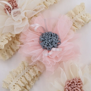 Dettaglio della fascia in pizzo per neonati con fiori in tulle e texture in rete