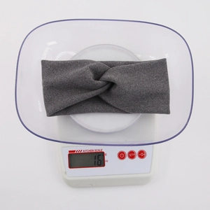 Lightweight grey twisted knit headband for babies and kids weighing 16g on a scale