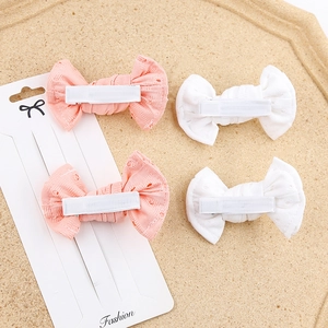 Detail of four lace hollow butterfly hair clips in pink and white on a display card