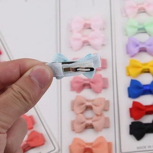 Detail showing the metal duckbill clip on a light blue bow hair clip for girls