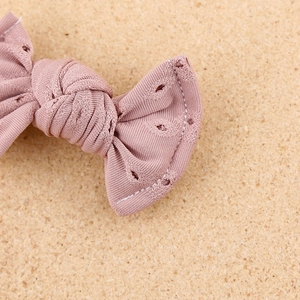 Close-up of pink lace eyelet bow hair clip showing rib texture and fine craftsmanship