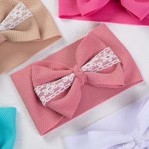 Detail of baby headbands with large lace bows in various soft colors and bubble fabric