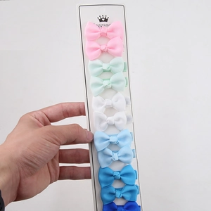 Detalle de 10 lazos para el pelo hechos a mano en cinta grosgrain sobre cartón