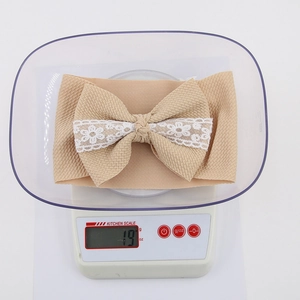 Infant waffle fabric headband with oversized bow and white lace floral detail on scale