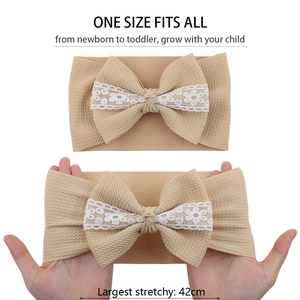 Detailed view of beige ribbed baby headband showing high elasticity and lace bow design