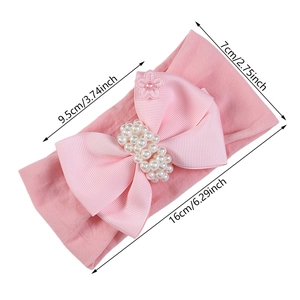 Bandeau rose pour bébé en nylon avec un grand nœud en perles et détail de fleur