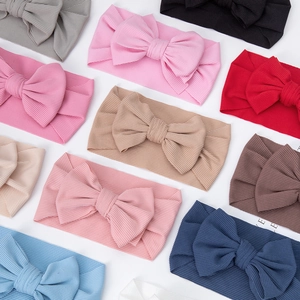 Detail of ribbed knit baby headbands with large bows in various vibrant colors