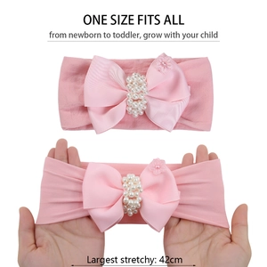 Bandeau bébé rose avec nœud perlé montrant une grande élasticité jusqu'à 42cm