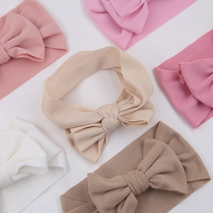 Detail view of multi-color ribbed knit baby headbands with large soft bow accents