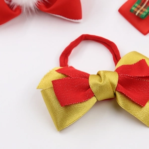 Gros plan d'un nœud de cheveux festif en satin rouge et doré pour accessoires de fille