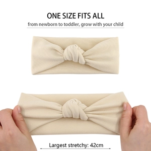 Detail view of cream baby headband showing super stretchy fabric and one size fit