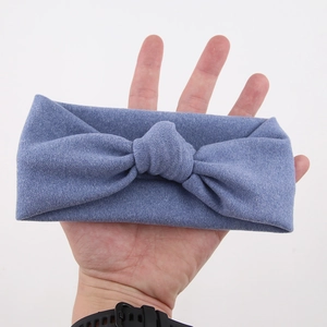 Detail view of light blue textured stretch fabric headband with a central bow knot
