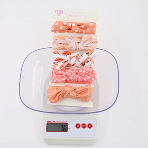 5-piece set of baby bow headbands with colorful prints displayed on a white scale