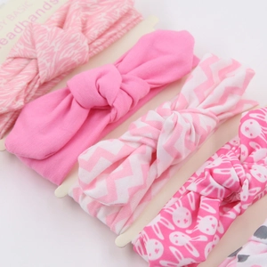 Detail view of 4-pack pink baby headbands with bow knots on a white card