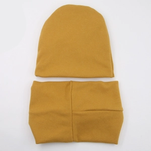 Detailed flat lay of mustard yellow knitted baby hat and neck warmer scarf set